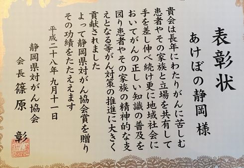 【表彰状】静岡県対がん協会賞 平成28年9月11日 あけぼの静岡さま 貴会は長年にわたりがんに苦しむ患者やその家族と立場を共有して手を差し伸べ続け更に地域社会においてがんの正しい知識の普及を図り患者やその家族の精神的な支えとなる等がん対策の推進に大きく貢献されました。よって静岡県対がん協会賞を贈りその功績をたたえます。平成28年9月11日静岡県対がん協会 会長 篠原彰